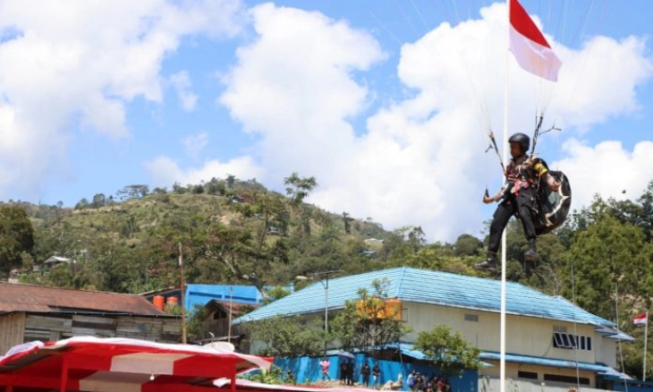 Personil Polres Tolikara Kibarkan Bendera Merah Putih Lewat Atraksi Paralayang
