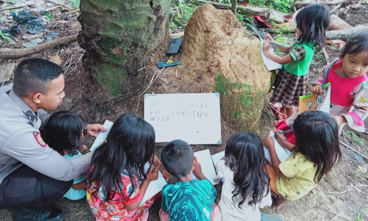 Dua Polisi Polda Jambi Ajarkan Membaca Anak Suku Anak Dalam Air Hitam